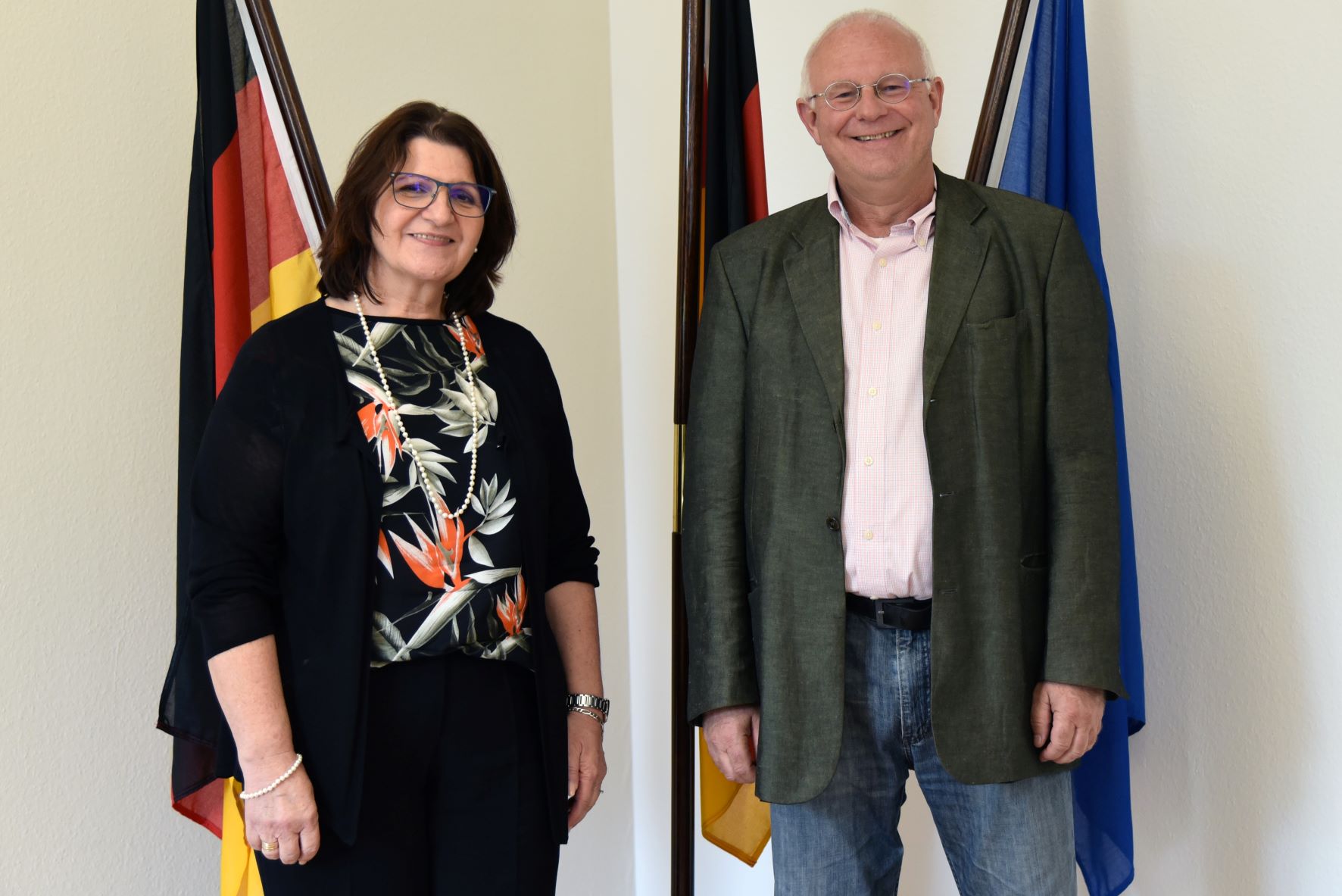 Staatssekretärin Altesleben und Michael Löher vor der Deutschland- und Europaflagge