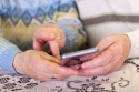 Foto: junge und alte Hände, die ein Smartphone benutzen, istock.com / ©Ocskaymark