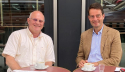 Foto: v.l.n.r.: Michael Löher und Staatssekretär Andreas Bothe an Café-Tischen