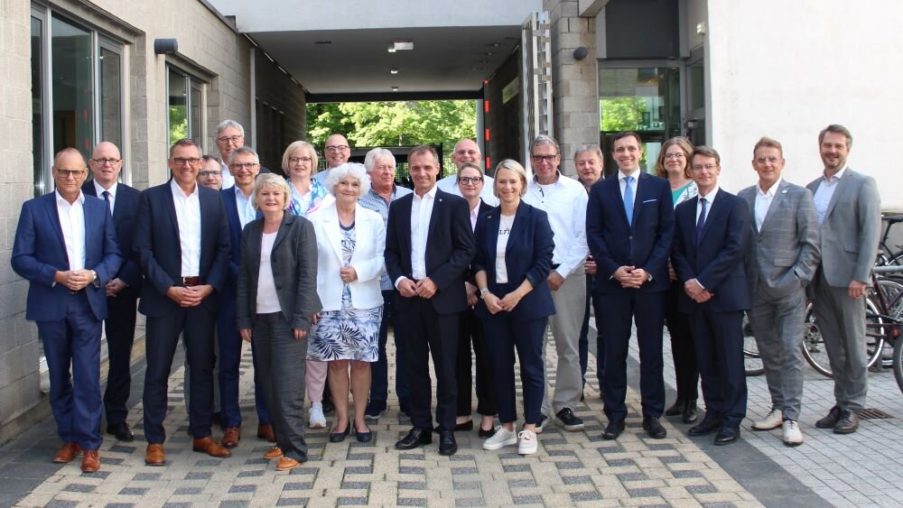 Das Bild ist ein Gruppenfoto von den Foto den Mitgliedern des Ausschusses des Deutschen Städte- und Gemeindebundes. Die Mitglieder stehen im Innenhof der Geschäftsstelle des Deutschen Vereins. –