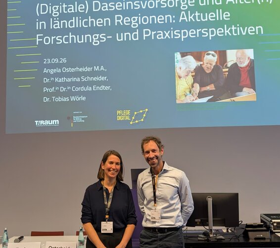 Foto zeigt Dr. Anna Richter und Dr. Tobias Wörle bei einem gemeinsamen Vortrag zum Thema "Digital gestützte Daseinsvorsorge. Neue Spielräume für Kommunen und ambulante Pflege in ländlichen Räumen?"