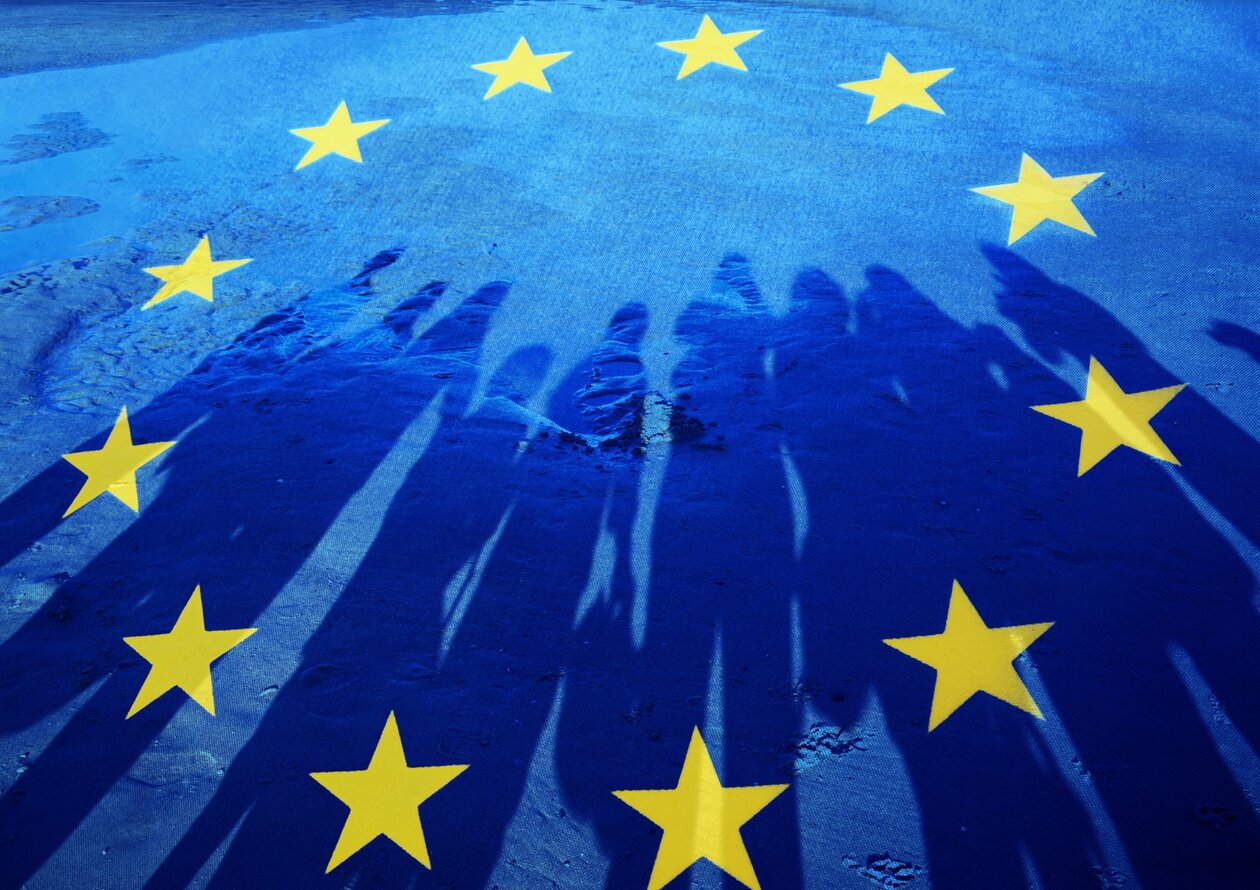 Foto einer EU-Flagge mit Schatten einer Gruppe von Menschen