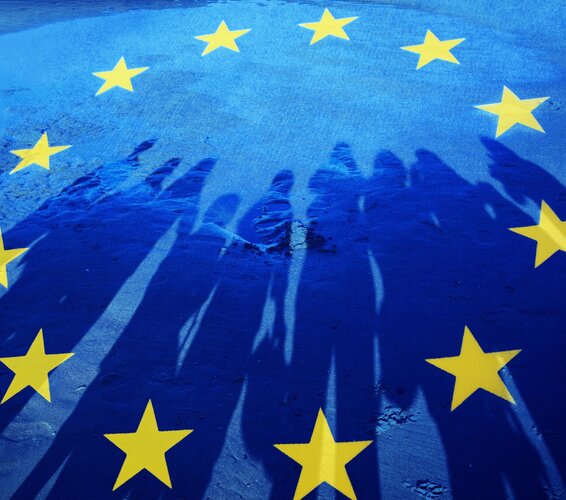 Foto einer EU-Flagge mit Schatten einer Gruppe von Menschen
