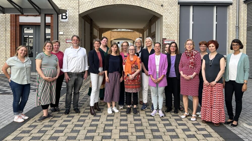 Das Bild ist ein Gruppenfoto von den Teilnehmenden des Workshops im Innenhof des Deutschen Vereins –
