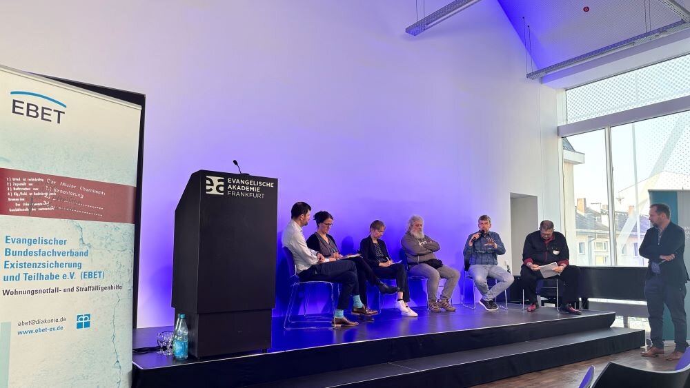 Foto von den Podiumsteilnehmenden auf der Bühne –