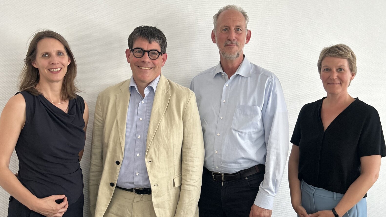 Dr. Verena Staats, Staatssekretär Thomas Götz, Ulrich Wendte und Nora Schmidt posieren vor einer Wand in den Geschäftsräumen des Deutschen Vereins –