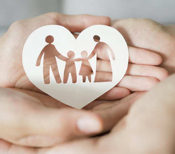 Erwachsenen- und Kinderhände übereinander, Scherenschnitt einer Familie in Herzform – 